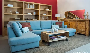 Salón con paredes rojas y sofá azul