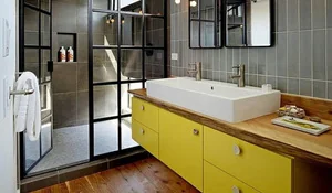 Baño de estilo industrial con mueble de lavabo amarillo