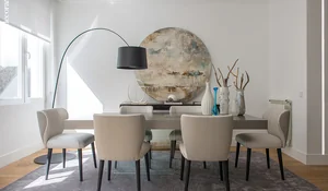 Comedor en tonos beige y lámpara en arco de una casa reformada