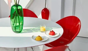 Comedor con mesa blanca acompañada de sillas rojas