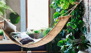 Rincón co hamaca de mimbre y plantas de interior de HKLiving