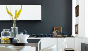 Muebles de cocina blancos con pared pintada de gris oscuo