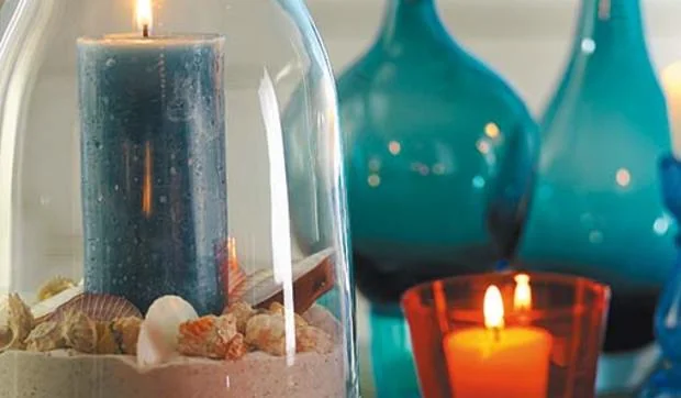 Centro de mesa con velas y arena para iluminar las noches de verano