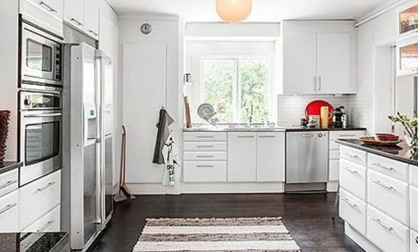 Cocina blanca bien distribuida, con armarios en tres frentes