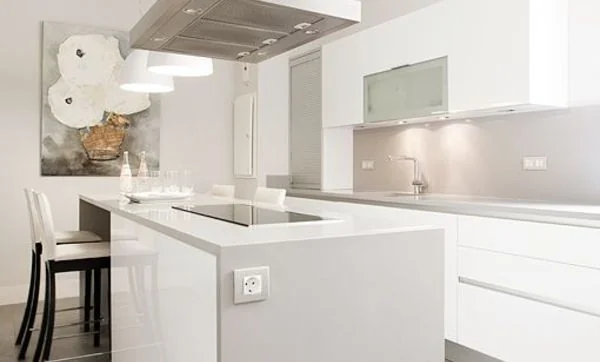 Cocina con isla de cocción y mesa de desayuno