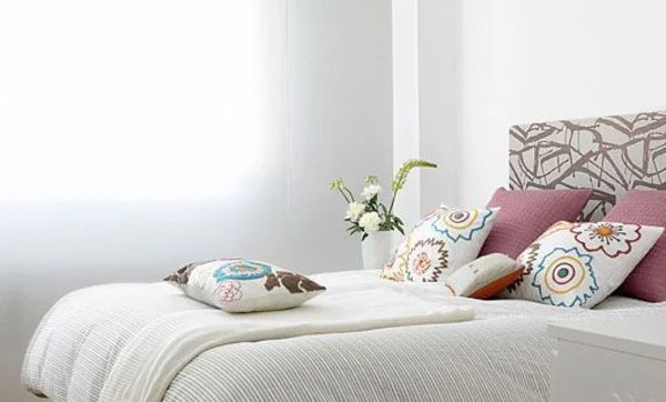 Dormitorio pequeño decorado en blanco con notas de color