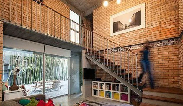 Un salón con paredes de ladrillo visto y una acogedora terraza