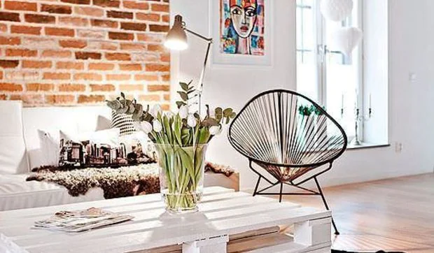 Salón con paredes de ladrillo visto, en un piso de estética loft